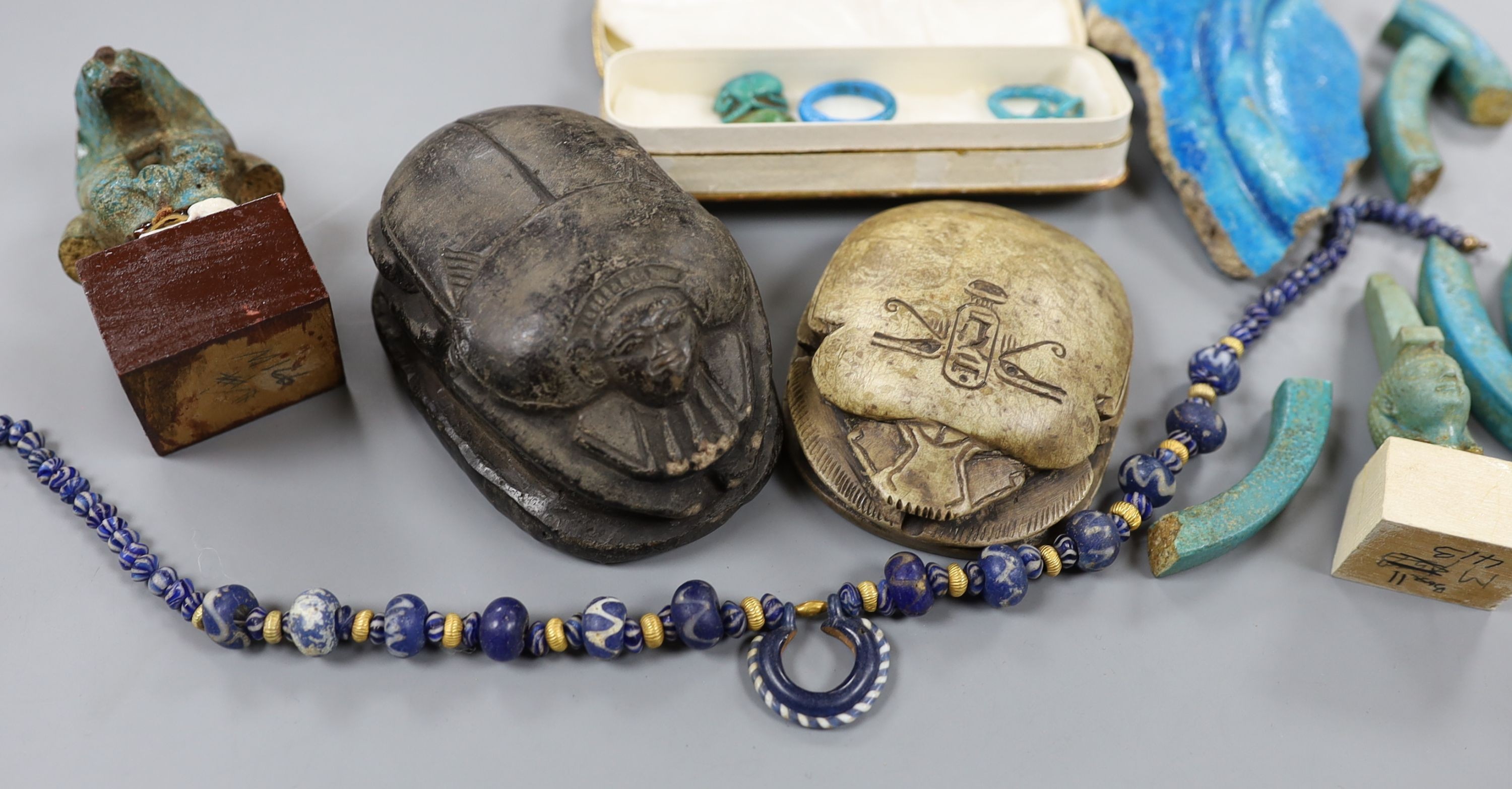 A small collection of Egyptian artefacts including necklace, scarabs, rings and a later scarab, part of the Josephine Dubois collection